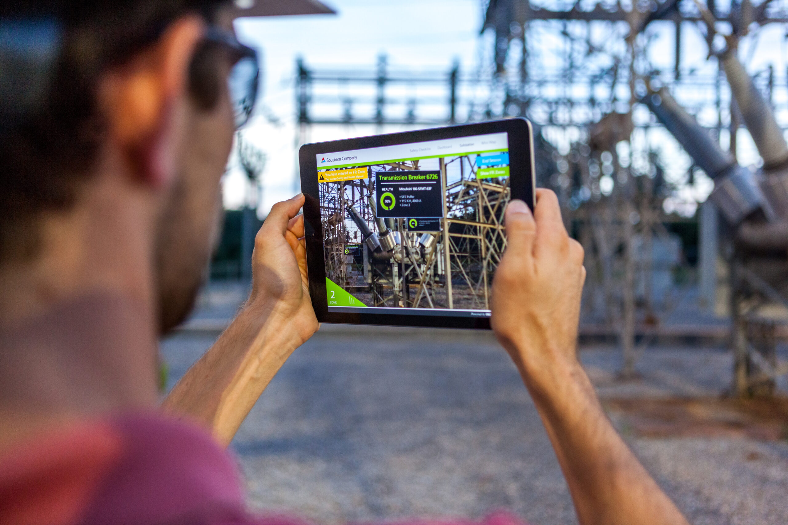 Worker using AR on tablet in substation